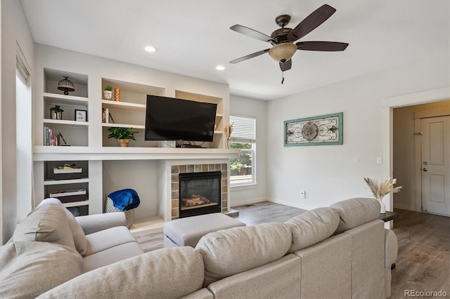 10955 Dearborne Dr, Parker, CO 80134 - living room featuring ceiling fan, wood finished floors, a fireplace, recessed lighting, and built in shelves