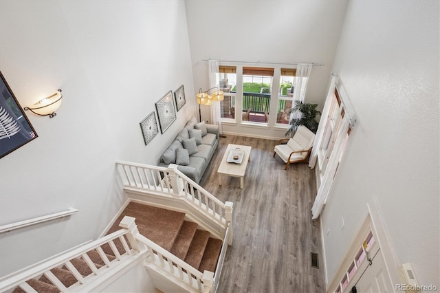 10955 Dearborne Dr, Parker, CO 80134 - staircase featuring a towering ceiling, wood finished floors, and a chandelier