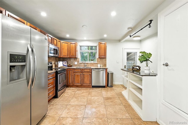 2025 Otis St, Edgewater, CO 80214 - kitchen with appliances with stainless steel finishes, backsplash, brown cabinets, light stone counters, and recessed lighting