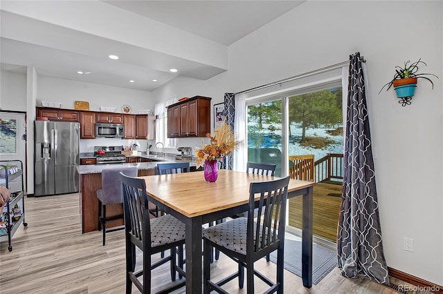 dining space with sink and light hardwood / wood-style flooring