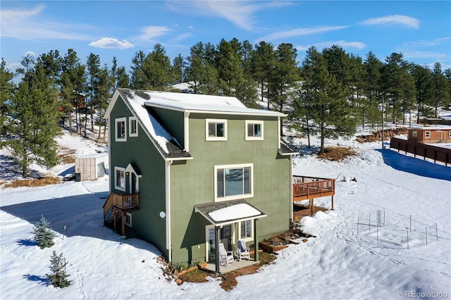 view of snow covered back of property