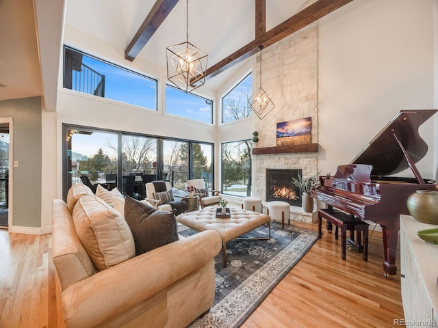 living room featuring wood-type flooring, a stone fireplace, high vaulted ceiling, and beam ceiling