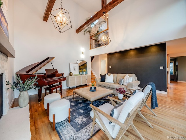 living room with a notable chandelier, beam ceiling, high vaulted ceiling, and light hardwood / wood-style floors