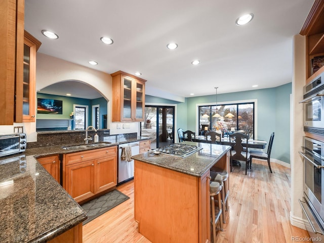 kitchen featuring appliances with stainless steel finishes, sink, hanging light fixtures, a center island, and kitchen peninsula