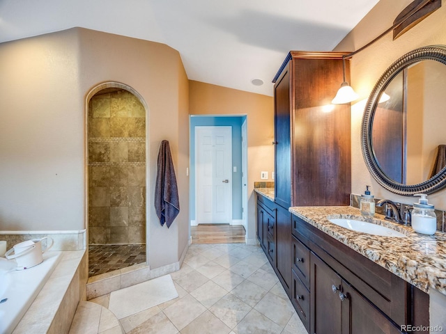 bathroom with lofted ceiling, shower with separate bathtub, tile patterned flooring, and vanity