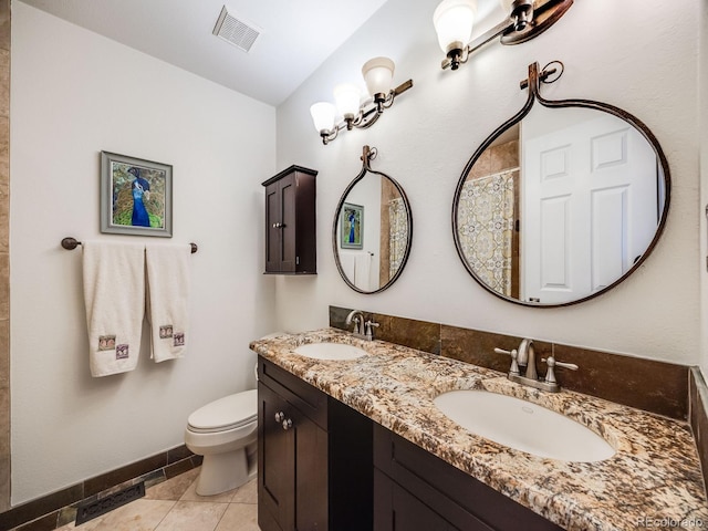 bathroom featuring vanity, toilet, and tile patterned flooring