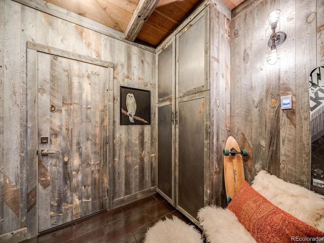 interior space with beam ceiling, wood ceiling, and wooden walls