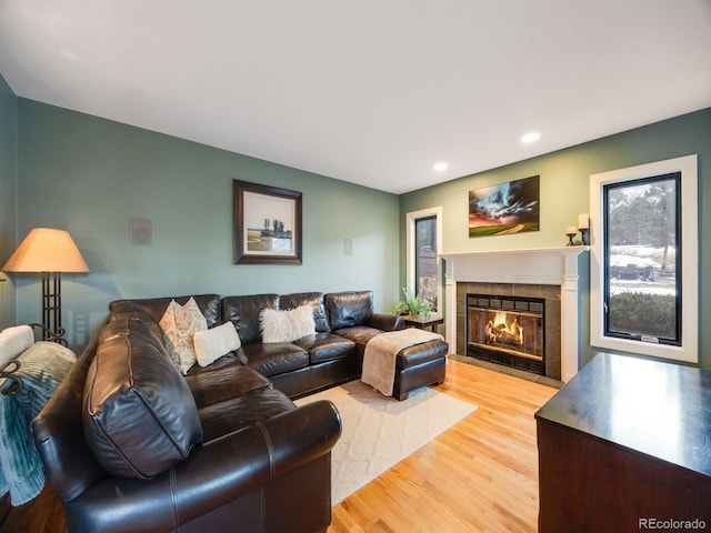 living room with a fireplace, light wood-style flooring, and recessed lighting