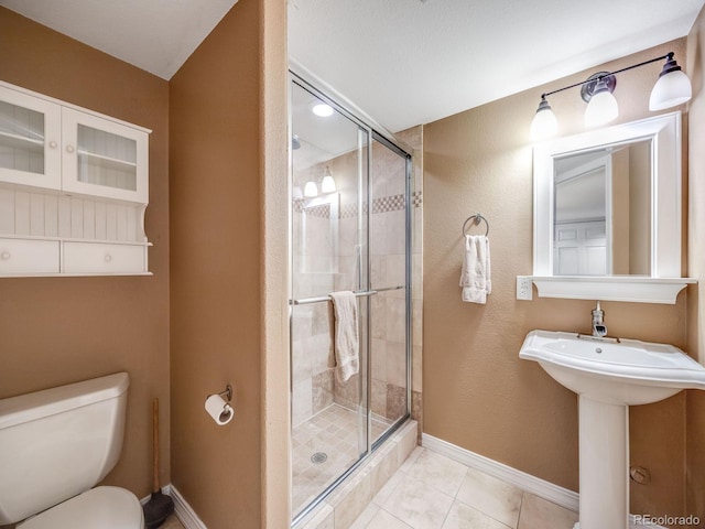 bathroom featuring a stall shower, toilet, baseboards, and tile patterned floors