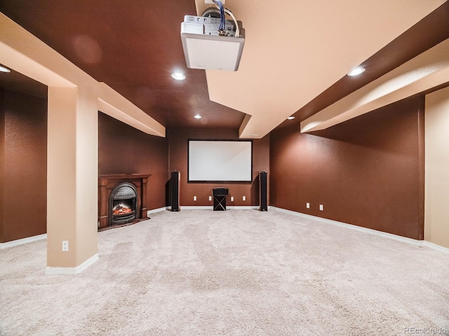 carpeted cinema room featuring a lit fireplace, baseboards, and recessed lighting