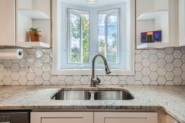 kitchen featuring decorative backsplash, sink, white cabinets, and light stone counters