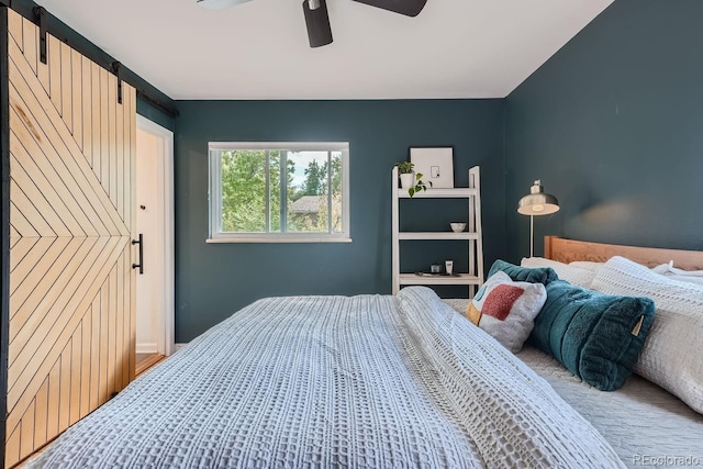 bedroom featuring a barn door and ceiling fan