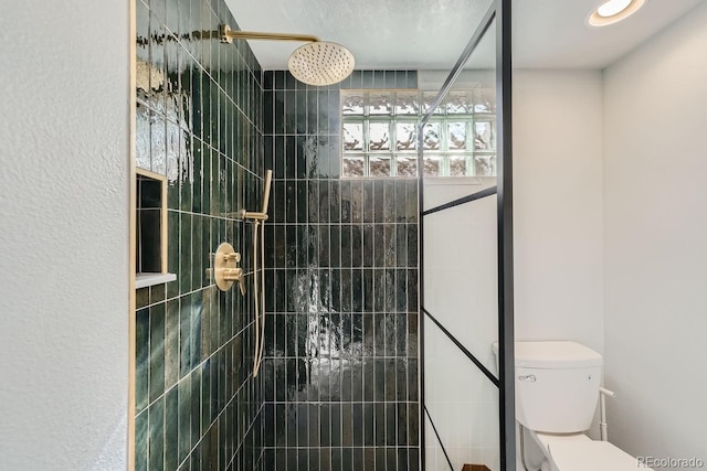 bathroom featuring toilet and tiled shower