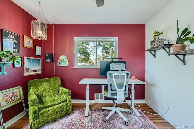 office featuring a notable chandelier and hardwood / wood-style flooring