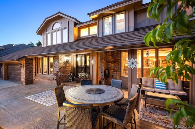 back of property with outdoor lounge area and a patio