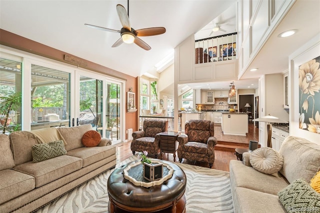 living room featuring ceiling fan, wood-type flooring, and a healthy amount of sunlight