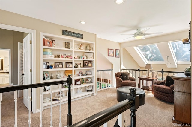 sitting room featuring ceiling fan, a healthy amount of sunlight, carpet flooring, and lofted ceiling with skylight