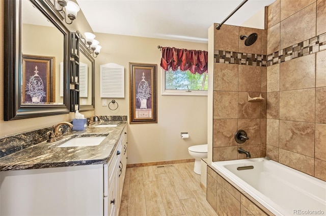 full bathroom with tiled shower / bath, vanity, toilet, and wood-type flooring