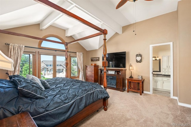 carpeted bedroom featuring ceiling fan, connected bathroom, and vaulted ceiling with beams