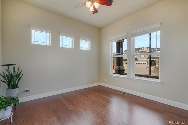 unfurnished room with ceiling fan and dark hardwood / wood-style flooring