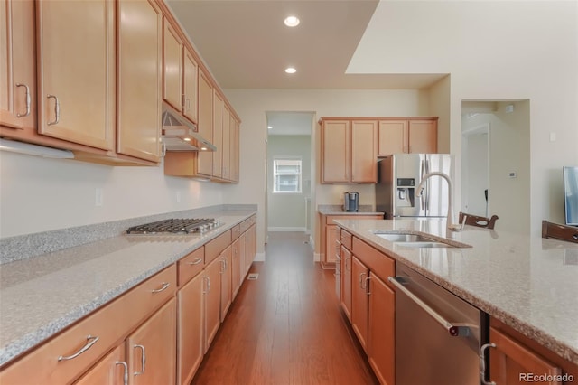 kitchen featuring sink, appliances with stainless steel finishes, light stone countertops, light brown cabinetry, and light wood-type flooring