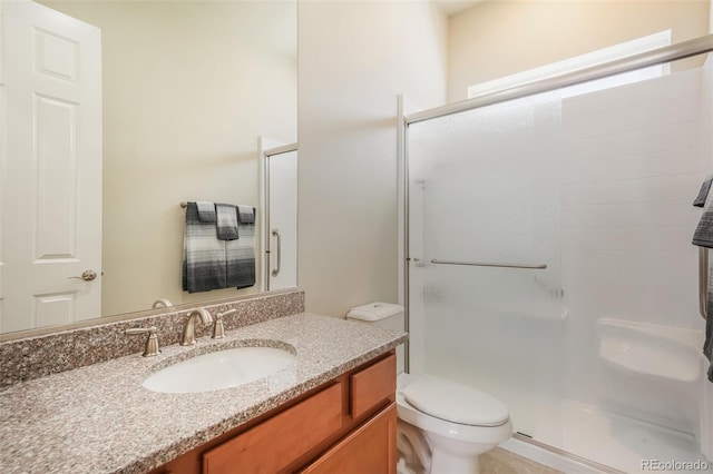 bathroom with vanity, toilet, and a shower with shower door