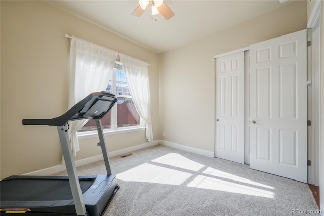 workout area with ceiling fan and light colored carpet