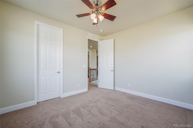 unfurnished bedroom featuring light colored carpet and ceiling fan