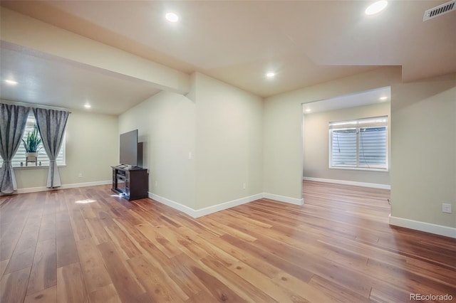 unfurnished living room with lofted ceiling with beams and light wood-type flooring