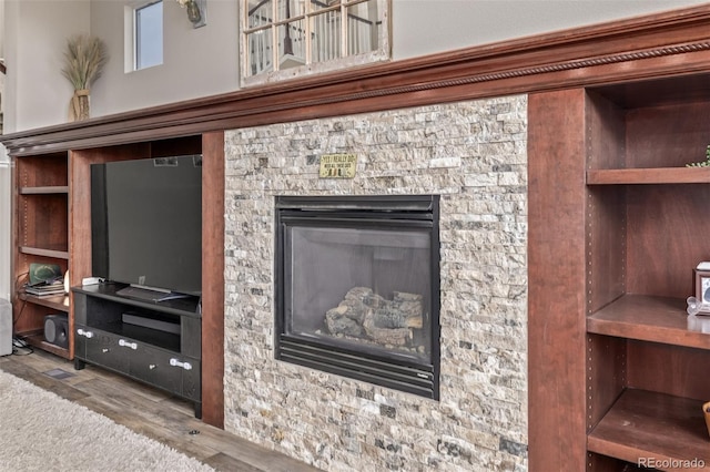 room details featuring a stone fireplace and wood finished floors