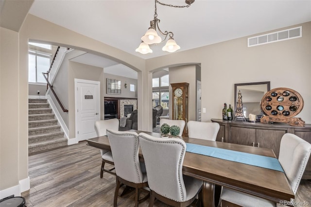 dining area featuring stairway, arched walkways, a healthy amount of sunlight, and visible vents