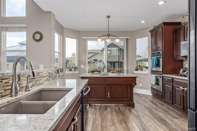 kitchen featuring light wood-type flooring, a sink, a healthy amount of sunlight, and stainless steel appliances