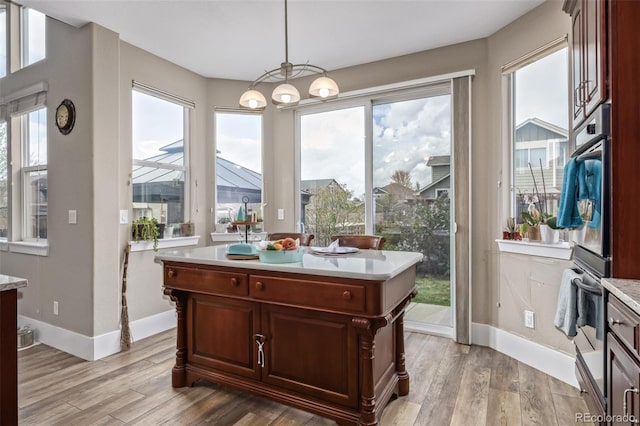 dining room featuring baseboards, a wealth of natural light, and light wood-type flooring