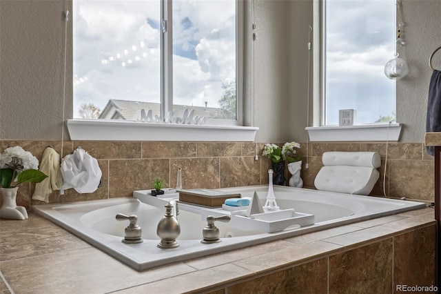 full bathroom featuring a garden tub and a textured wall