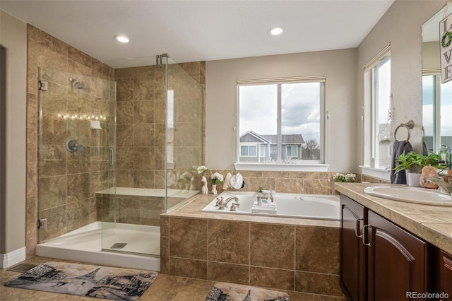 bathroom with vanity, plenty of natural light, a shower stall, and a garden tub