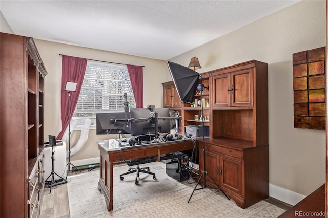 office area featuring baseboards and light wood-style flooring