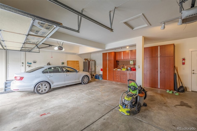 garage featuring a garage door opener and freestanding refrigerator