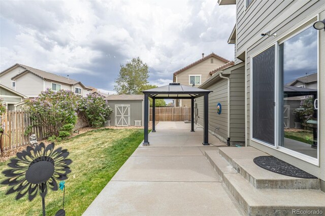 view of patio / terrace featuring a gazebo, an outbuilding, a fenced backyard, and a storage unit