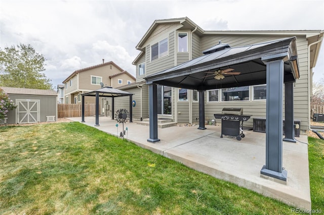 back of house featuring ceiling fan, a storage shed, a gazebo, a yard, and a patio
