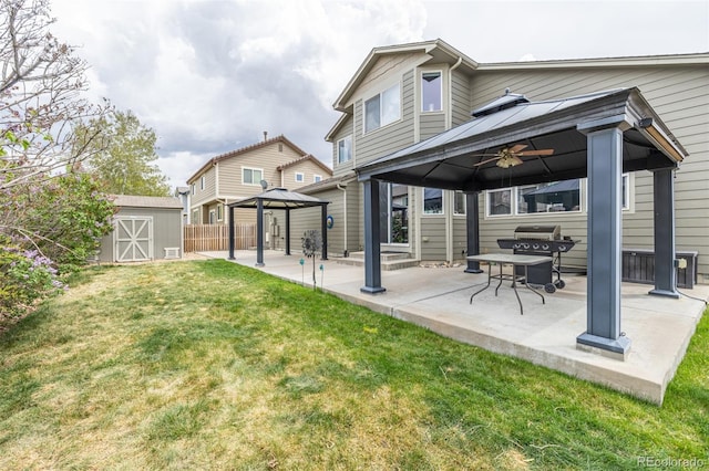 back of property with a gazebo, a shed, an outbuilding, a lawn, and a patio