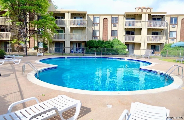 pool with a patio and fence