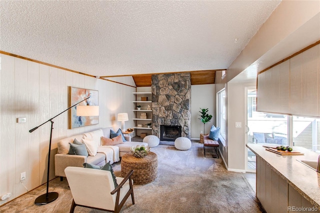 living room featuring wooden walls, light colored carpet, a textured ceiling, and a fireplace