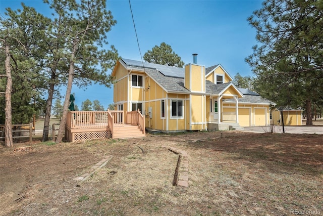 37677 Sable Ridge Rd, Elizabeth, CO 80107 - view of front facade with a chimney, fence, solar panels, covered porch, and a garage