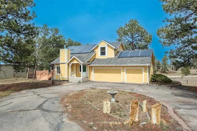 37677 Sable Ridge Rd, Elizabeth, CO 80107 - traditional-style house with driveway, a chimney, roof mounted solar panels, a garage, and fence