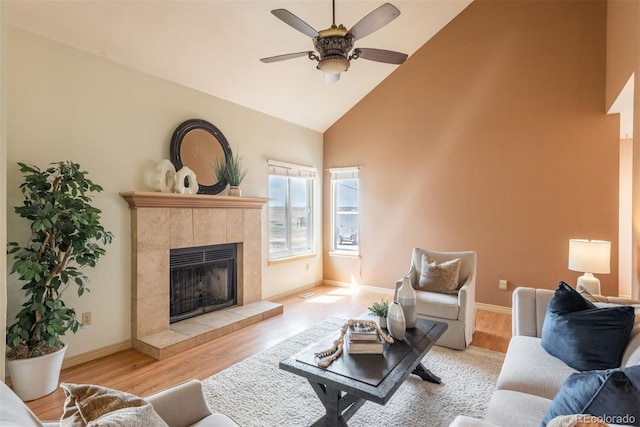 37677 Sable Ridge Rd, Elizabeth, CO 80107 - living area featuring high vaulted ceiling, a tile fireplace, a ceiling fan, wood finished floors, and baseboards