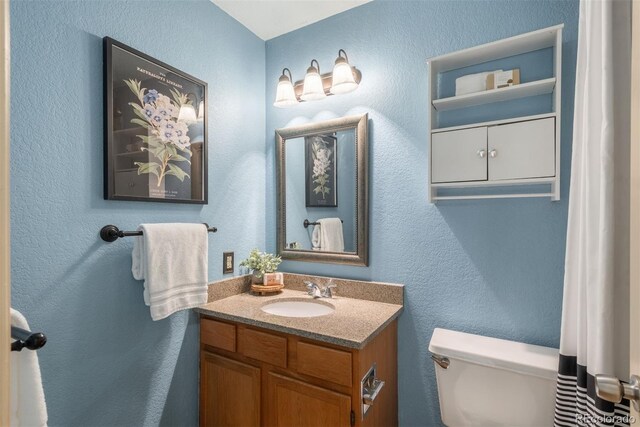 37677 Sable Ridge Rd, Elizabeth, CO 80107 - bathroom featuring toilet, a textured wall, and vanity