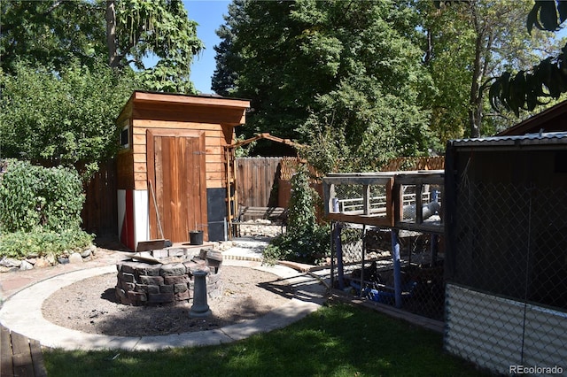 exterior space with a storage shed and a fire pit