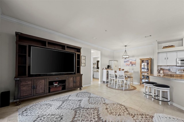 living room featuring an inviting chandelier, crown molding, and light tile patterned flooring