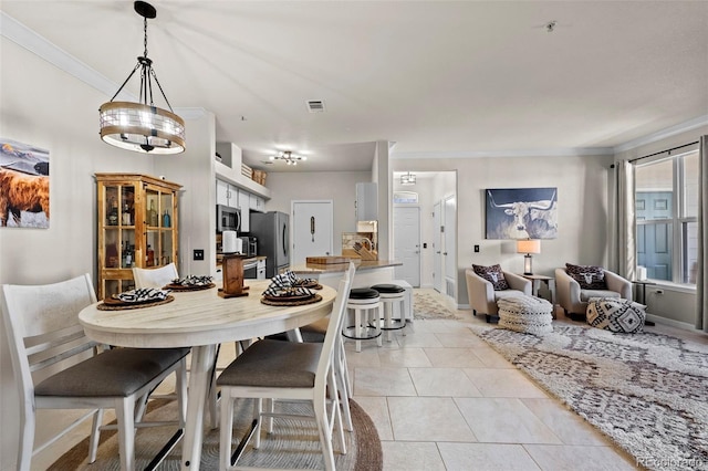 dining area with light tile patterned floors and ornamental molding