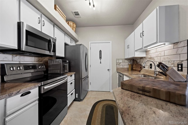 kitchen featuring white cabinetry, stainless steel appliances, sink, and backsplash